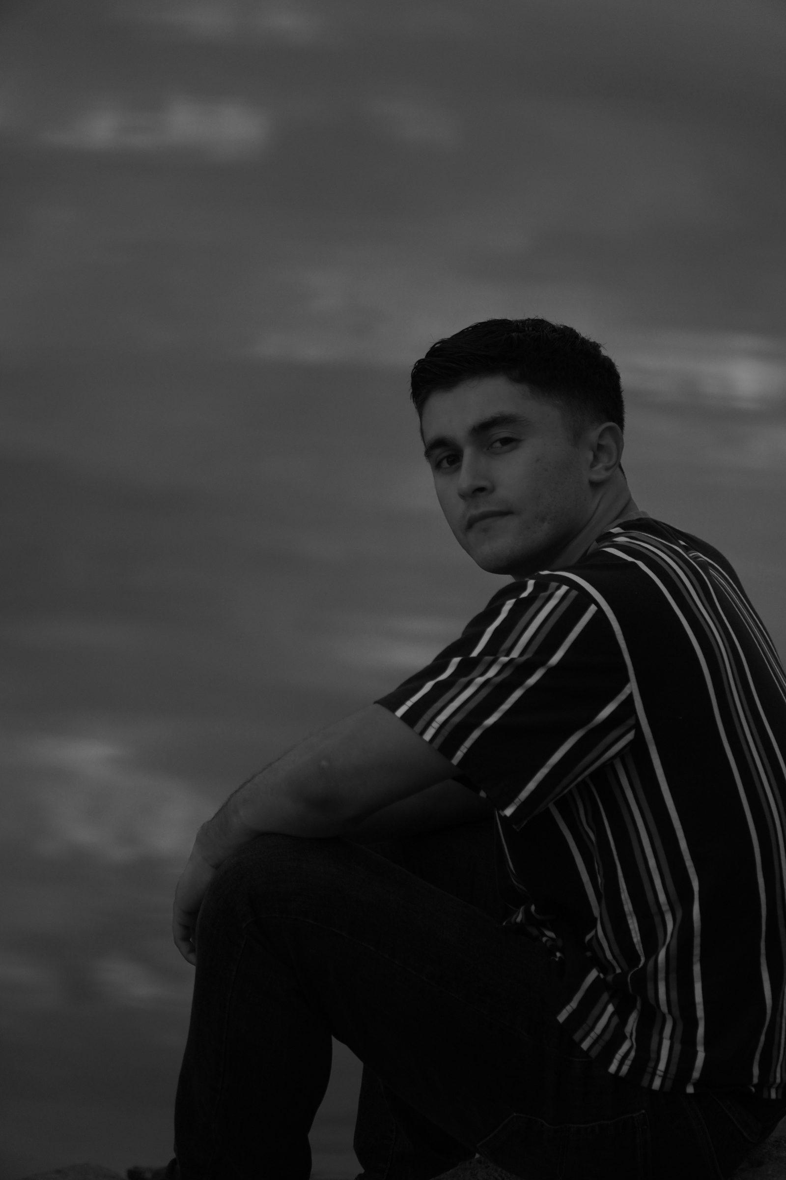 Black and white senior portrait, moody sunset sky